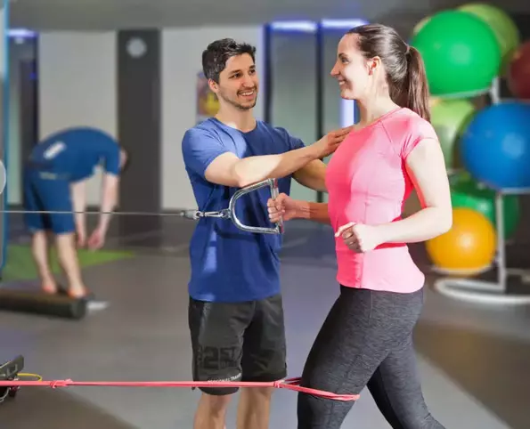 Personal Fitness Trainer optimiert die Körperhaltung einer Frau