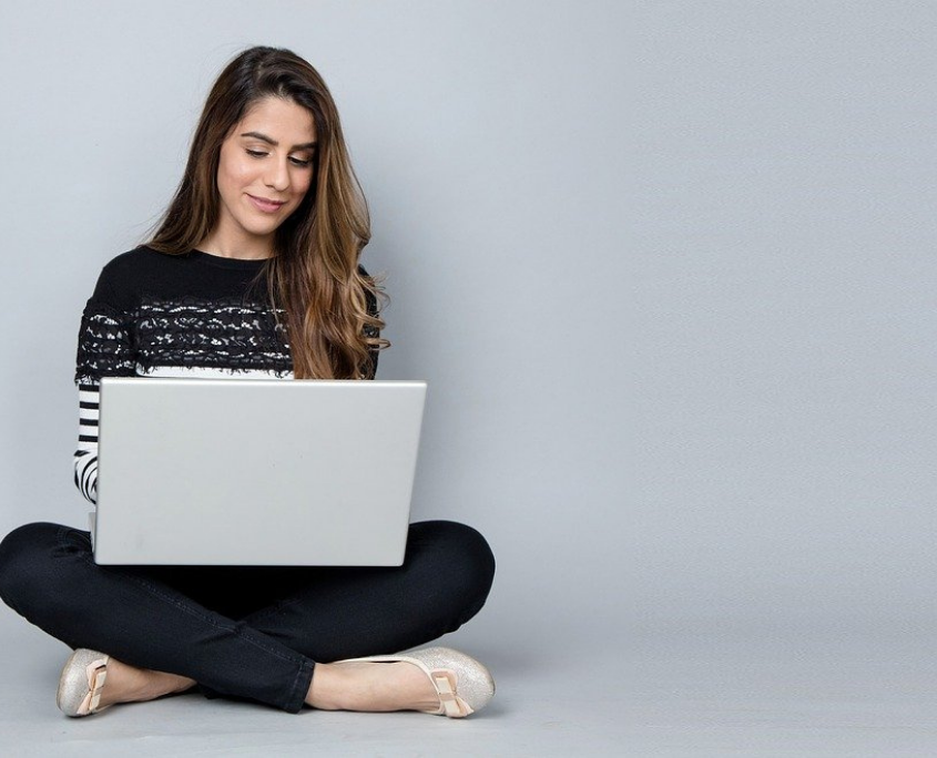 Frau mach Online-Fitnesskurs am Laptop